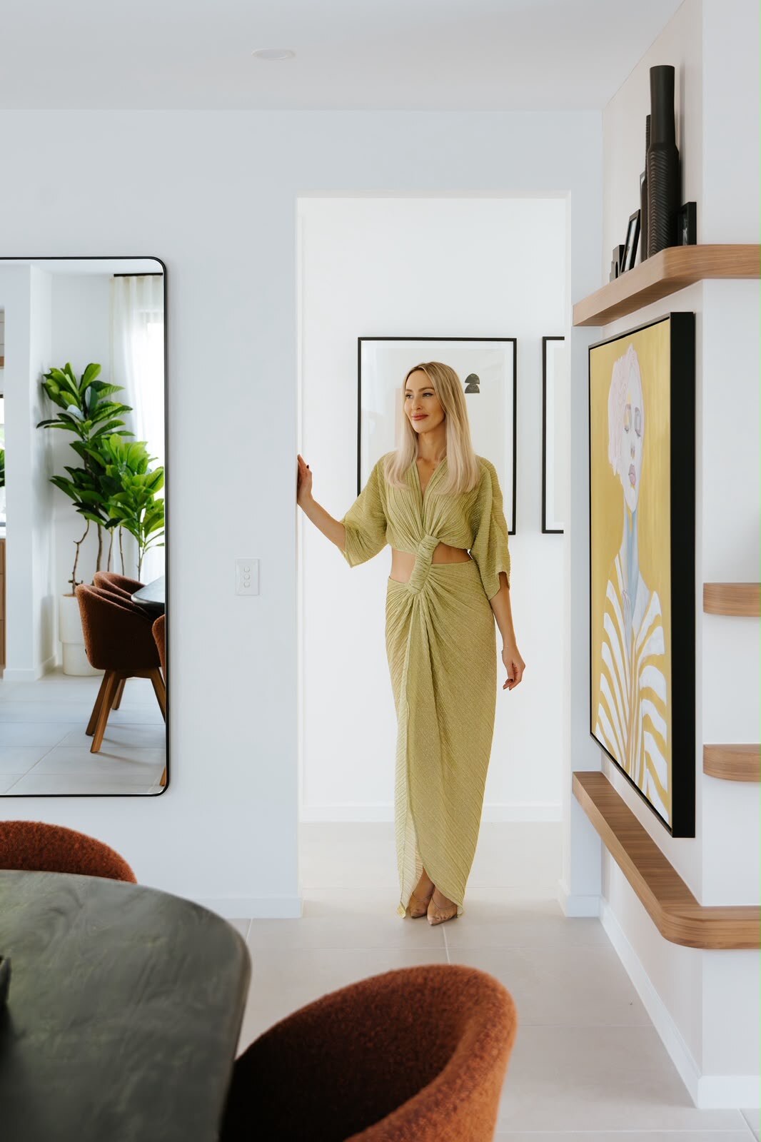Liz Tilley in a green dress in a residential hallway